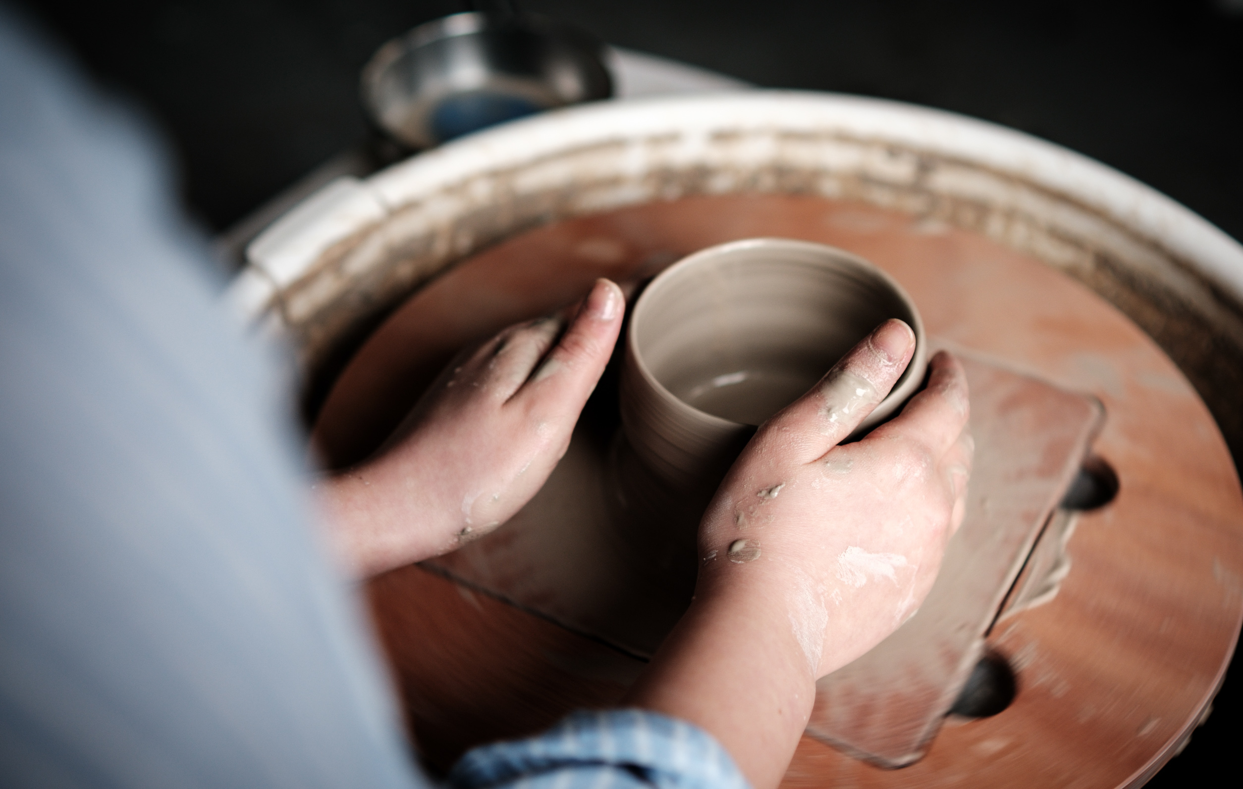 Professional pottery studio with ceramic bowls and vases on wooden shelves - pottery classes and ceramic workshops for beginners and advanced students